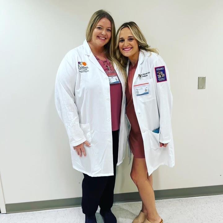 picture of two pediatric residents posing while wearing white medical coats